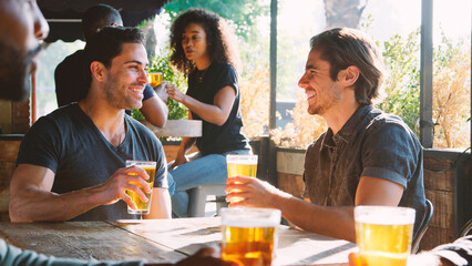 Two Male Friends Meeting In Bar Enjoying Drink Together