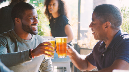 Two Male Friends Meeting In Bar Enjoying Drink Together
