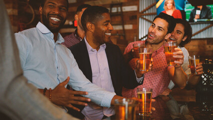 Group Of Male Friends On Night Out For Bachelor Party In Bar Making Toast Together