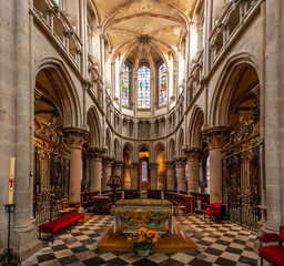 Obraz premium Semur-En-Auxois, France - 10 21 2025: Collegiate Church of Notre-Dame. Panoramic view of the transept and naves with stained glass windows and altar at the back