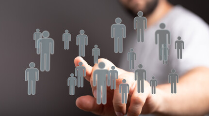 Close-up of a man's finger interacting with floating human icons. A visualization of social...