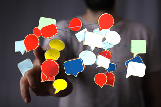 Hand touching digital network of speech bubbles representing social media, conversation, information and online - Powered by Adobe