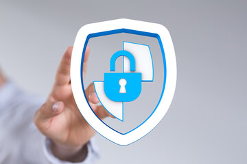 This image represents digital security and protection. A hand touches a shield with a padlock, symbolizing data privacy, security, an