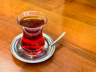 Traditional Turkish tea served in a glass cup on a wooden table