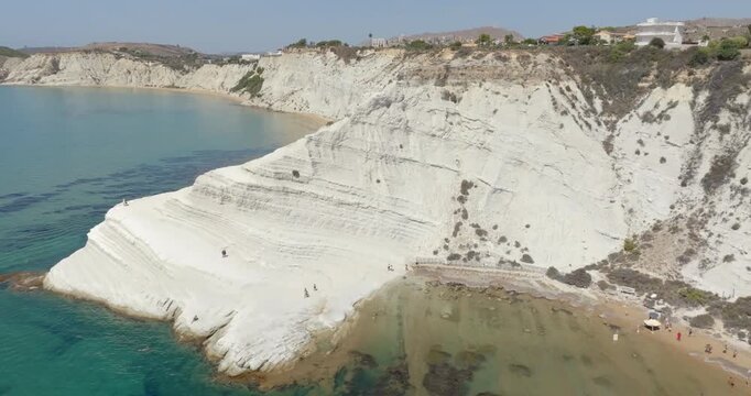 Aerial view of the Scala dei Turchi (Stair of the Turks or Turkish Steps) on the coast of Realmonte, near Agrigento, Sicily, Italy. It's a rocky cliff and tourist attraction. The sea is turquoise.