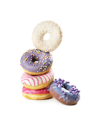 A stack of five vibrant donuts showcases different colors and toppings. Flavors include lavender, pink, and a white donut with sprinkles, inviting indulgence and joy.