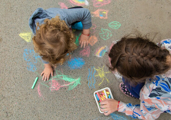 Children draw with chalk on the pavement. Selective focus.