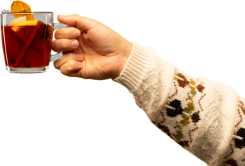 Hand holding hot mulled drink with citrus slices in cozy sweater sleeve on transparent background. Concept of warm holiday aesthetics, seasonal beverage advertising, and winter promo visuals.
