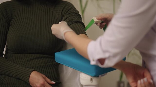 Close-up of unrecognizable patient receiving blood test preparation from medical professional, getting blood sample drawn for laboratory analysis in clinical healthcare environment, slow motion. - Powered by Adobe