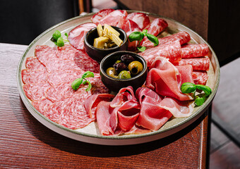 Savory charcuterie platter with meats and olives served on a wooden table