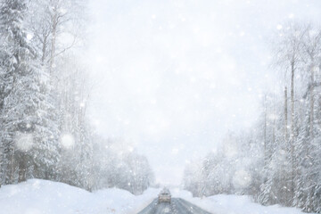 Naklejka premium snowfall on a winter road, abstract background, blurred highway backdrop snowy landscape