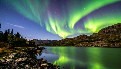 Green aurora borealis dances above a tranquil lake surrounded by rocky shores and mountains under a starry night