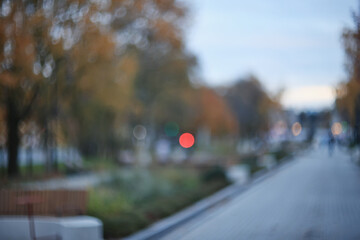 Autumn blurred background of trees in a city park, seasonal backdrop for design