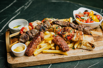 A plate of food with a variety of meats and vegetables, including chicken, beef, and shrimp