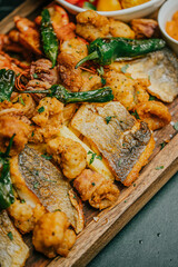 A plate of food with a variety of meats and vegetables on a wooden board. The dish looks delicious and appetizing
