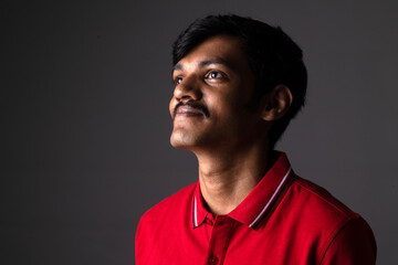 Portrait of Indian middleclass young man 
isolated on studio background. Close shot of confident...