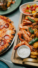 A pizza and shrimp platter are on a wooden board. The pizza is covered in pepperoni and cheese. The shrimp are in a white bowl
