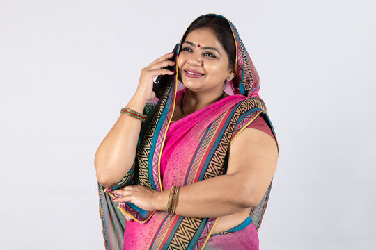 Rural indian woman talking on mobile phone at studio. Use of wireless technology, Digital Technology in india, Mobile banking and Telecom industry. Communication device - Powered by Adobe