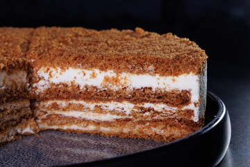Layered Crumb Cake With Cream Filling On Dark Plate