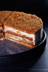 Layered Crumb Cake With Cream Filling On Dark Plate
