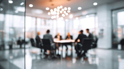 Fototapeta premium A blurred meeting room scene with several professionals seated around a table, discussing in a modern office environment.