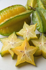 Close-up of sliced star fruit on a wooden board, showcasing the fruit's unique star shape and juicy texture, with a shallow depth of field.