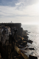 Dramatic Coastal Cliffs and Crashing Waves at Cabo Carvoeiro in Peniche, Portugal with Lighthouse on the Horizon