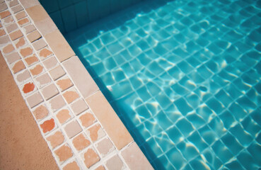 Obraz premium A swimming pool with clear blue water and tiled edges creating a relaxing outdoor scene
