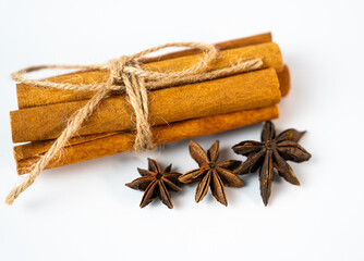 Beautiful bundle of cinnamon sticks with star anise on clean background. Concept of winter comfort, spice aroma, and natural wellness.