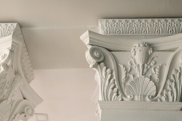 Beautiful architectural moldings on the columns under the ceiling. White