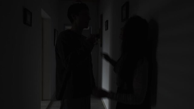 Silent couple fighting in the dark hallway, psychological tension and emotional distance