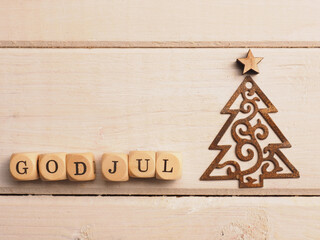 God Jul on wooden cubes, Scandinavian christmas background with a rusty Christmas tree shape