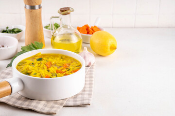 Tasty Italian Penicillin Soup, autumn winter immunity booster chicken vegetables orzo soup. Traditional european comfort food with ingredients for cooking on white table
