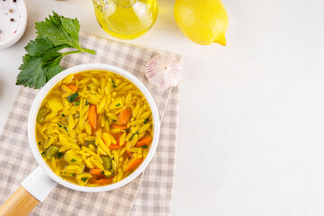 Tasty Italian Penicillin Soup, autumn winter immunity booster chicken vegetables orzo soup. Traditional european comfort food with ingredients for cooking on white table