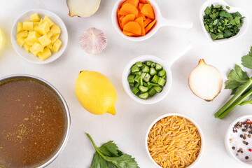 Tasty Italian Penicillin Soup, autumn winter immunity booster chicken vegetables orzo soup. Traditional european comfort food with ingredients for cooking on white table