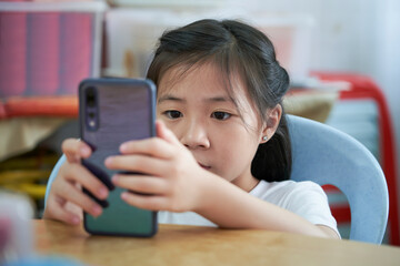 Young asian girl using smartphone, digital content consumption
