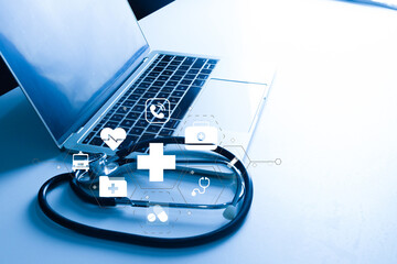 Healthcare technology (HealthTech) concept. Stethoscope on laptop with virtual medical icons. Telemedicine, digital health, and electronic health record (EHR) innovation.