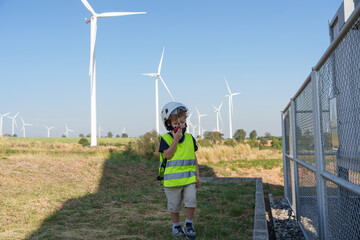 Children are running on a natural energy farm such as windmills and electricity.