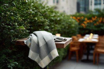 romantic dinner setting featuring cozy plaid blanket and glowing candles against backdrop of twinkling garlands