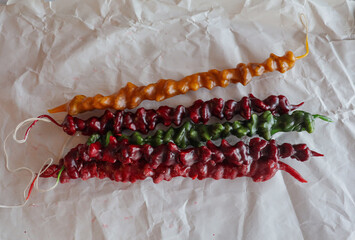 Colorful Churchkhela: Traditional Georgian Sweet Treat on White Paper. These delicious, chewy candies are a popular dessert in Georgia, made with nuts and grape juice