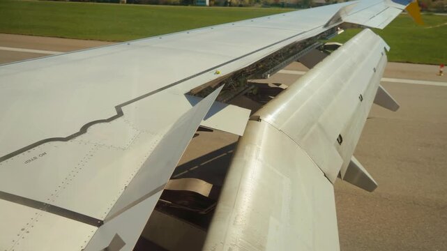 Plane decelerating on runway using airbrake. Jet slowing down after touchdown with speed brakes deployed. Aircraft reducing velocity along tarmac, deploying spoilers for braking