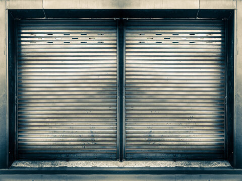 Closed steel shutter door of old grunge warehouse, storage or storefront for metal door background and textured.