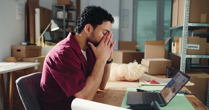 Ecommerce, headache or man in office with laptop for distribution backlog, logistics fail or bad review. Computer, exhausted person or migraine for courier delay, supplier problem or reputation risk.