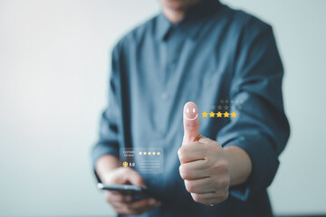 Customer satisfaction concept. Man uses smartphone to give a 5-star rating and positive review. Thumbs up with happy face icon signifies excellent service, quality, and best customer experience.