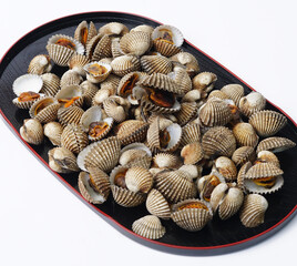 Small Clam Shells or called kerang darah in Asia On Black Plate Create Coastal Seafood Display For Food Styling