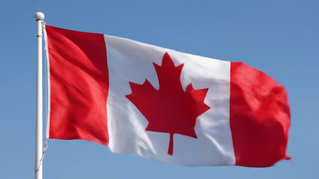 Canadian flag waving against a clear blue sky symbolizing national identity