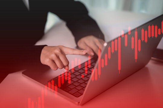 A woman is pointing at a laptop screen with a red background