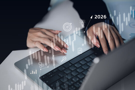 A woman is typing on a laptop with a screen that has a graph of the year 2016 - Powered by Adobe