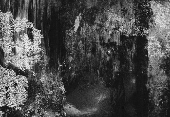 Obraz premium Dark cave tunnel opening framed by rock walls and stalactites, mysterious chamber with rough textures and faint light seeping through crevice to create eerie atmosphere