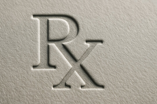 Macro image of the embossed &ldquo;Rx&rdquo; symbol on textured paper, representing the universal sign for prescriptions and pharmaceutical medicine in healthcare.